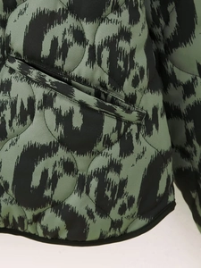 Detailed macro view of quilted diamond pattern and animal print pocket on jacket