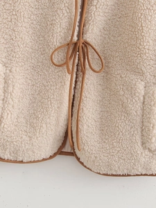 Detail of cream fleece vest with brown suede ties and soft textured fabric finish