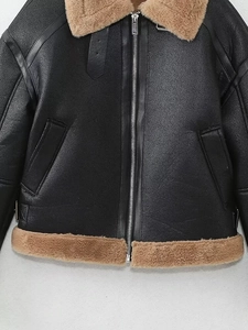 Détail du blouson aviateur noir avec texture simili cuir et col en fourrure marron pelucheux