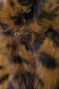 Detailed macro view of faux animal fur texture and silver metal snap button closure