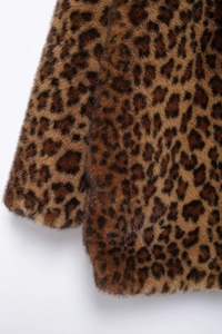 Dettaglio del cappotto in pelliccia sintetica leopardata con trama morbida e cuciture