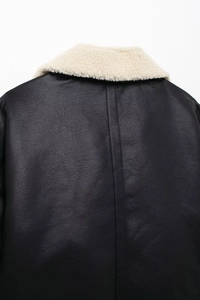Détail d'une veste en cuir noir avec un col épais en fausse fourrure de couleur crème