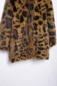 Close-up of leopard print faux fur coat showing thick plush texture and animal pattern detail