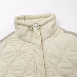 Veste matelassée beige à col montant avec coutures ondulées et cordons de serrage