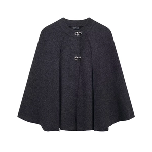 Detail of dark grey knit cape coat featuring round neck and circular metal buckle closure