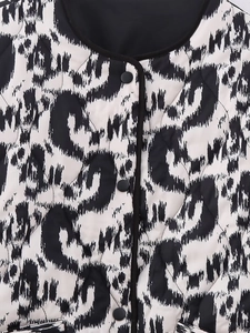 Detail of black and white leopard print quilted jacket with diamond stitching and snap buttons