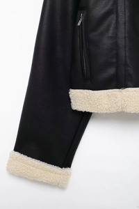 Détail d'une veste en cuir noir avec bordure en peau de mouton et zip métallique