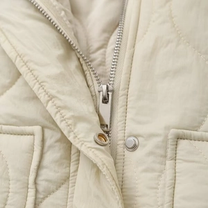 Veste sans manches matelassée crème pour femme avec col montant et surpiqûres