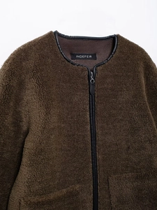 Close-up of brown fleece jacket with black leather trim and branded neckline detail