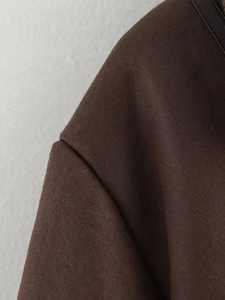 Detail of shoulder seam on dark brown faux suede jacket showing high-quality stitching