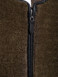 Detail of dark brown fleece jacket with black leather trim and silver metal zipper