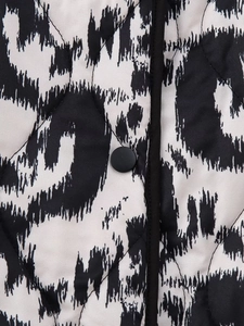 Detail of quilted leopard print jacket featuring diamond stitching and black snap button