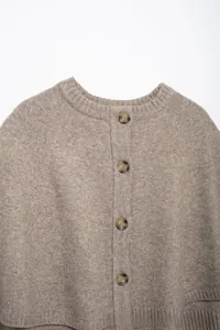 Detail of round neck and tortoise buttons on camel knit cardigan for women