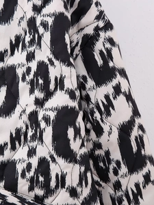 Macro detail of diamond quilted fabric with black and white abstract animal print on jacket