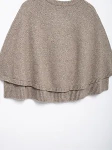 Close-up of light brown knit poncho featuring a double-layer design and ribbed edges