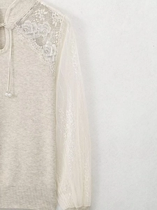 Detailed view of lace stitching and pearl drawstring on vintage knit top for women