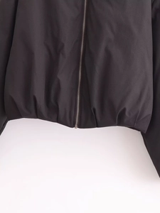 Détail de la fermeture éclair en métal et de l'ourlet élastique sur la veste noire