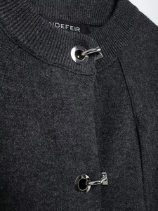 Detailed close-up of dark grey knit coat with premium silver horseshoe metal buckle