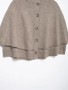 Detailed macro view of taupe knit texture and marbled buttons on women's cape coat