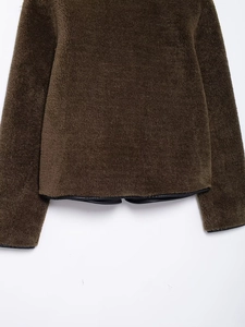 Detail of fleece texture on brown jacket with contrast black leather edge binding