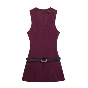 Détail de la combinaison plissée bordeaux à col en V profond avec fine ceinture noire