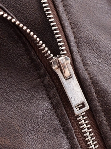 Close-up of vintage washed brown leather jacket with silver metal zipper detail