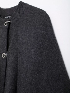 Close-up of dark grey knit cardigan featuring unique silver metal ring buckle closures