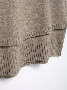 Detail of coffee brown knitted cape coat showing ribbed hem and soft wool texture
