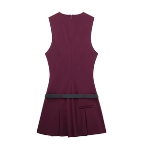 Détail de la robe courte plissée sans manches bordeaux avec une fine ceinture grise