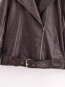 Detail of dark brown vintage faux leather jacket showing metallic zipper and belt buckle