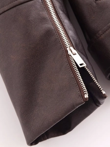 Detail of silver zipper on dark brown washed faux leather biker jacket with fine stitching