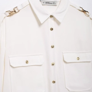 White crepe long sleeve blouse with golden relief buttons and chain shoulder epaulettes