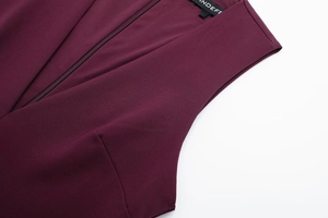 Gros plan détaillé du tissu de robe bordeaux avec fermeture éclair invisible et texture