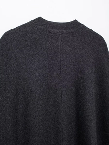 Detailed close-up of dark grey knit coat featuring ribbed neckline and center back seam