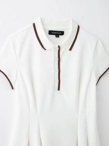 Détail du polo blanc à manches courtes avec bordure marron et décolleté boutonné