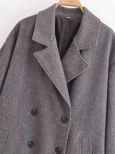 Dettaglio cappotto grigio in lana con bottoni a doppio petto e colletto a rever classico
