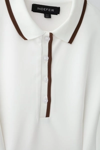 Gros plan sur la robe polo blanche avec bordure marron et texture en maille de qualité