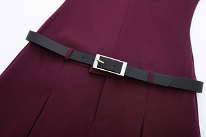 Détail de la taille d'une robe bordeaux avec une fine ceinture noire et boucle argentée