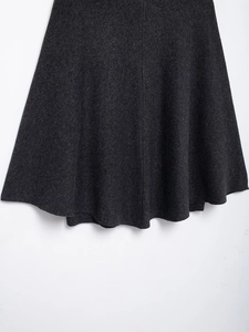 Detailed texture of thick charcoal grey wool knit fabric on A-line winter skirt
