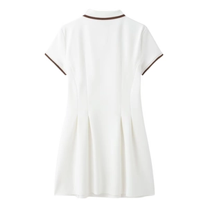 Détail d'une robe polo plissée blanche avec liseré marron au col et aux manches