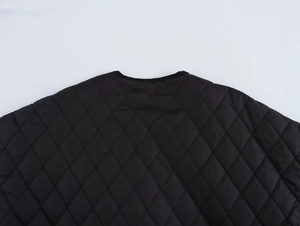 Close-up of diamond-quilted pattern and round elastic hem on black winter jacket