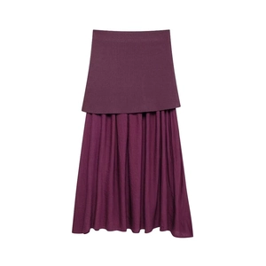 Detail view of purple knit skirt with double-layer pleats and textured fabric overlay