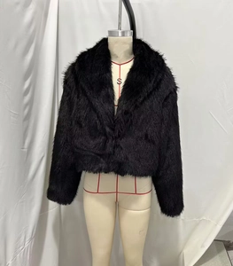 Detail of black faux fur jacket featuring plush texture and wide lapel design