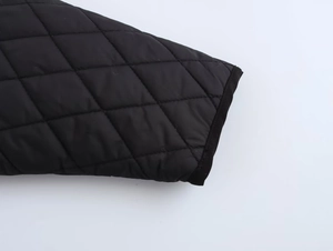 Close-up detail of black diamond quilted sleeve cuff on a stylish winter puffer jacket