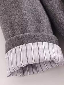 Dettaglio della manica del cappotto di lana grigio scuro con fodera gessata e cucitura fine