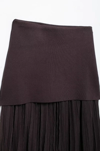 Detail view of high-waist dark brown pleated skirt featuring ribbed knit stitching details