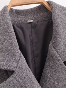 Dettaglio cappotto di lana grigio scuro con colletto a revers e fodera interna in nero