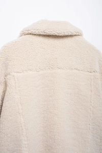 Detail of soft cream sherpa fleece texture and collar on a warm women jacket