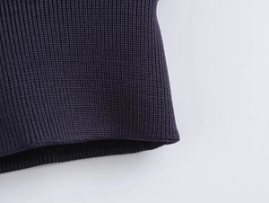 Detailed close-up of dark purple ribbed knit texture on a fashionable short baseball jacket