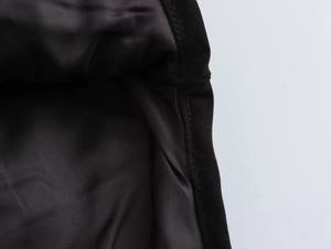 Detail shot of black diamond quilted jacket lining with precise stitching and hem finish